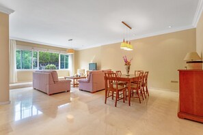 Un amplio salón con mesa de comedor, sofás y televisor.