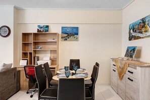 Un comedor con una mesa de madera, sillas negras y platos azules.