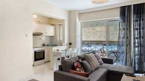 A modern apartment with a kitchen, dining area, and a living room with a sofa and a balcony. - Apartment 'Pallada' with Balcony, Wi-Fi and Air Conditioning (Athina)