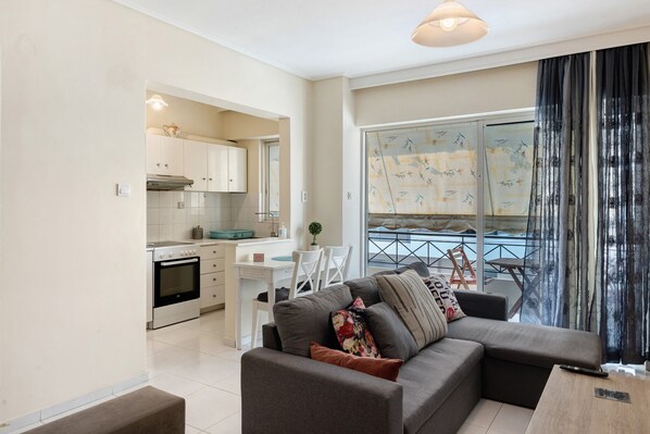 Un apartamento moderno con cocina, comedor y sala de estar con sofá y balcón.