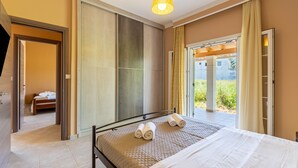 Ein Hotelzimmer mit Bett, Bad und Blick durch eine Glastür.