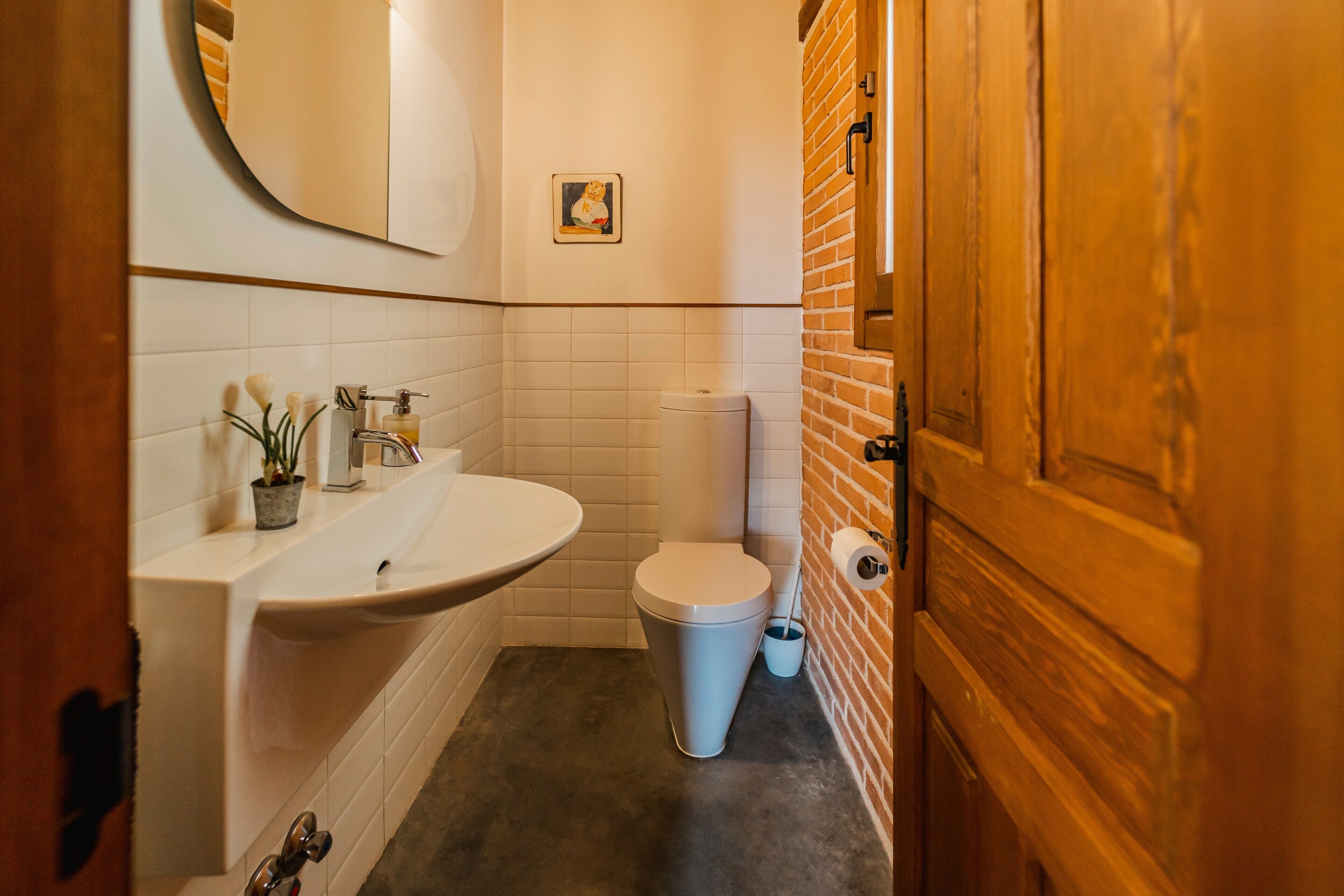 Een badkamer met een wastafel, toilet en spiegel.