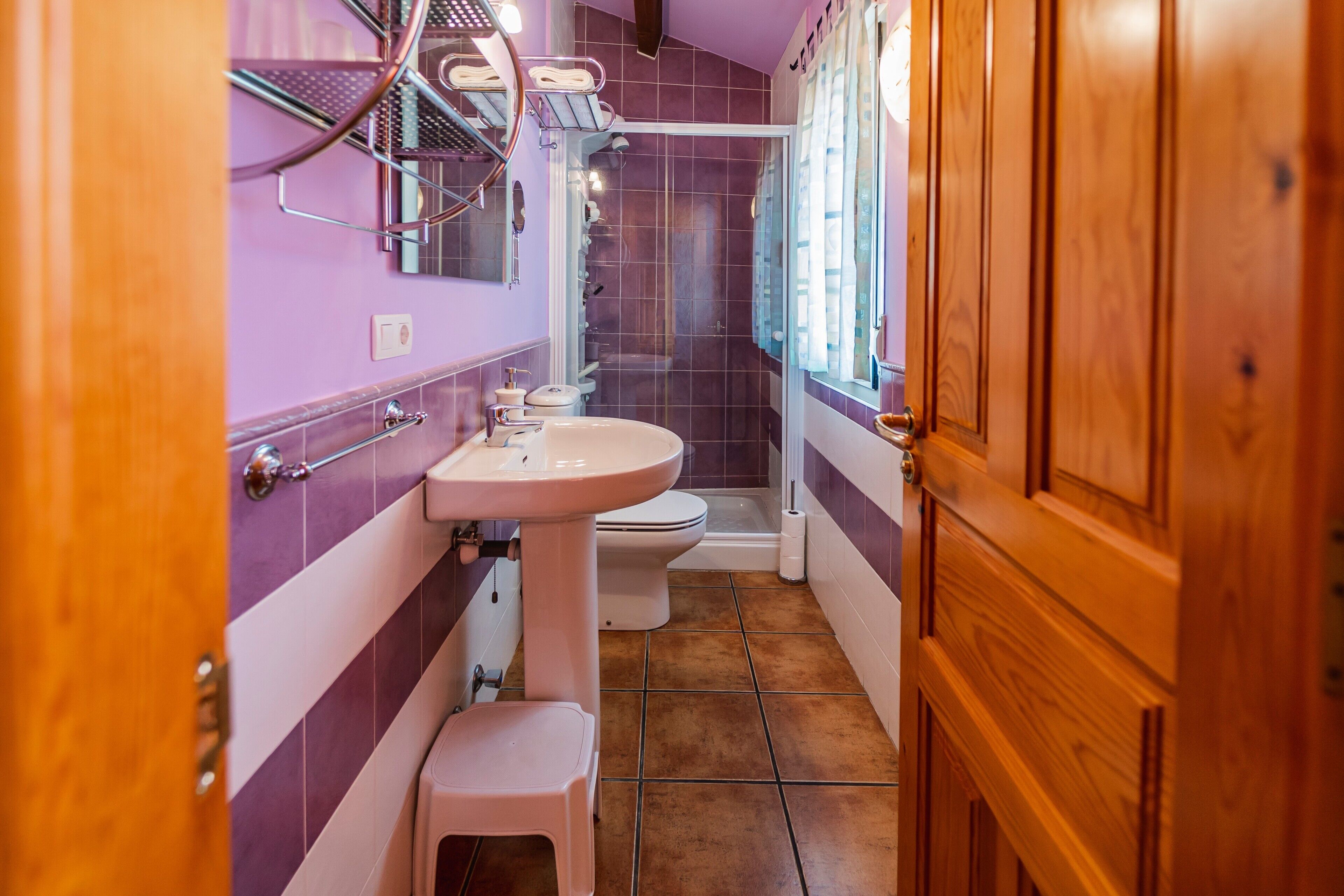 Un baño con lavamanos, inodoro y ducha.