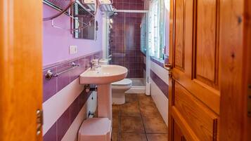 Un baño con lavamanos, inodoro y ducha.