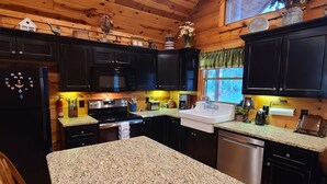 Una cocina con paredes de madera, encimeras de granito y electrodomésticos modernos.