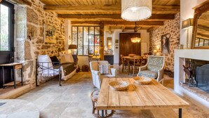 Un'atmosfera rustica con pareti in pietra, travi in legno, un camino e un'area pranzo.