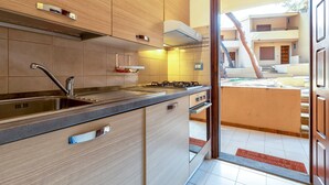 A modern kitchen with a sink, stove, and cabinets. - Holiday Home 'Casetta Al Mare' with Wi-Fi – A/C in Bedroom (Valledoria)