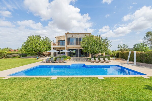 A modern house with a swimming pool, outdoor seating, and a well-maintained lawn. - Villa 'Viduleto' with Mountain View, Private Pool and Wi-Fi (Felanitx)