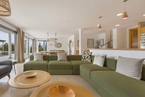 A modern living room with a sectional sofa, round coffee tables, and pendant lighting. - Villa 'Linda' with Sea View, Wi-Fi and Air Conditioning (Punta Prima)