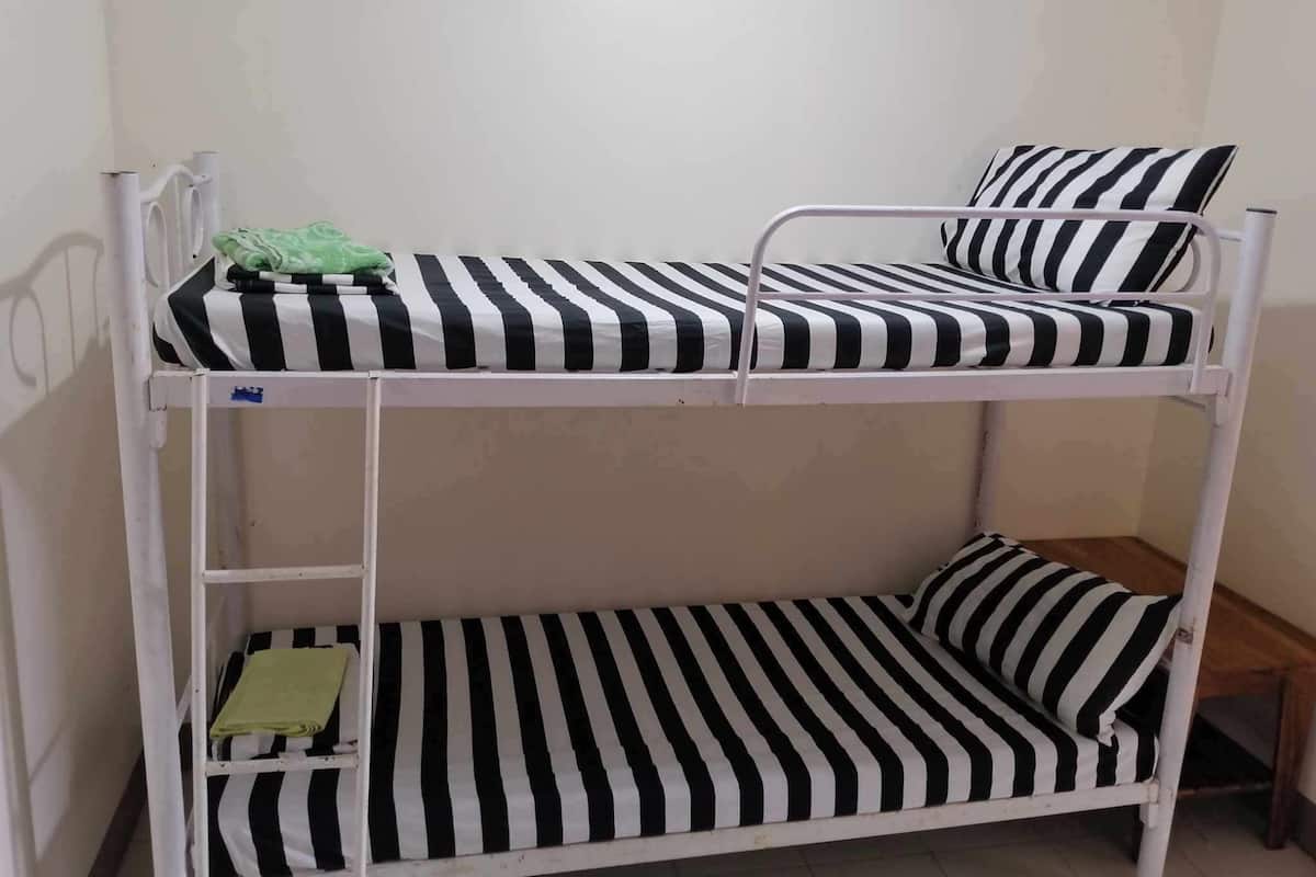 A bunk bed with black and white striped bedding.