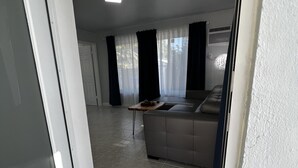 Un salon moderne comprenant un canapé, une table basse et un coin repas avec une table et des chaises.