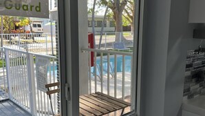 Un espace piscine doté d’un coin salon abrité et d’une clôture blanche.