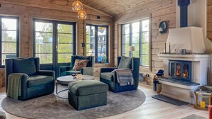 Una sala de estar acogedora con chimenea, ventanas amplias y asientos cómodos.