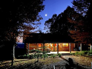 A cabin with a large window, a door, and a visible interior.