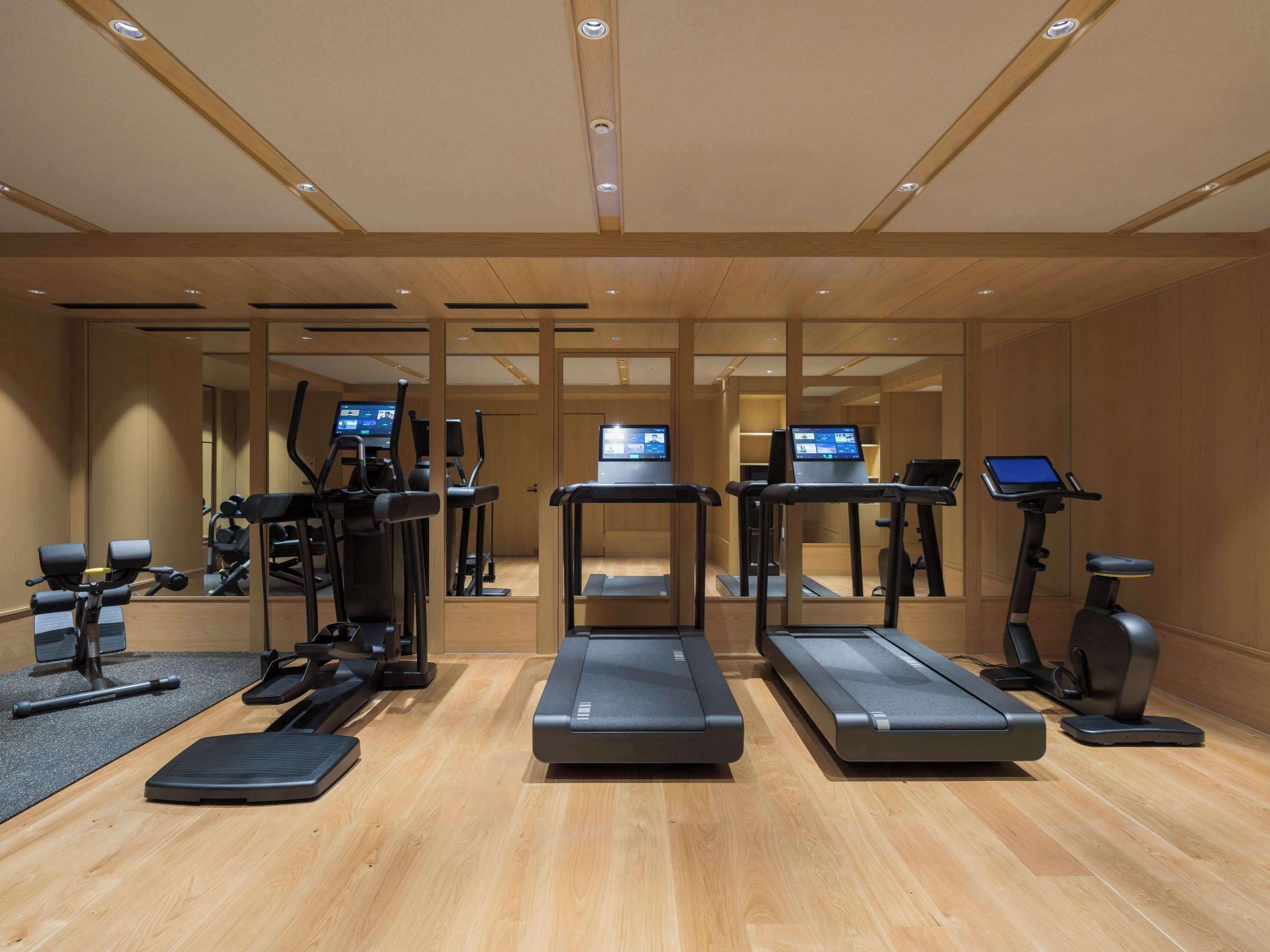 Een moderne sportschool met loopbanden, elliptische trainers en gewichten.