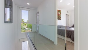 A modern bedroom with a bed, a painting, and a balcony with a glass railing. - Cozy home in Cartagena (Cartagena)