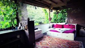 Una habitació acollidora amb un llit, un escriptori i una finestra amb vista a un paisatge verd i exuberant.