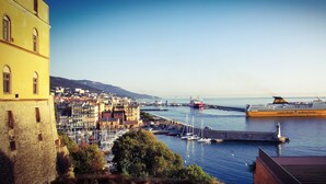 Paisatge urbà costaner amb un ferris groc gran, edificis històrics i una marina.