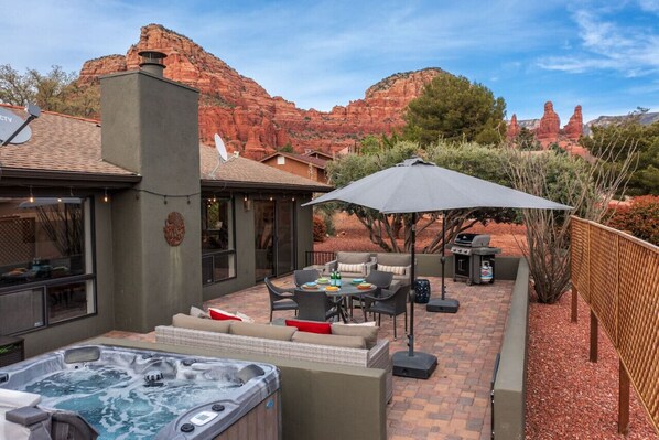 A patio area with outdoor furniture, a hot tub, and a grill. - High-end 3BR Home w/ Spa, Firepit & Red Rock Views (Sedona)