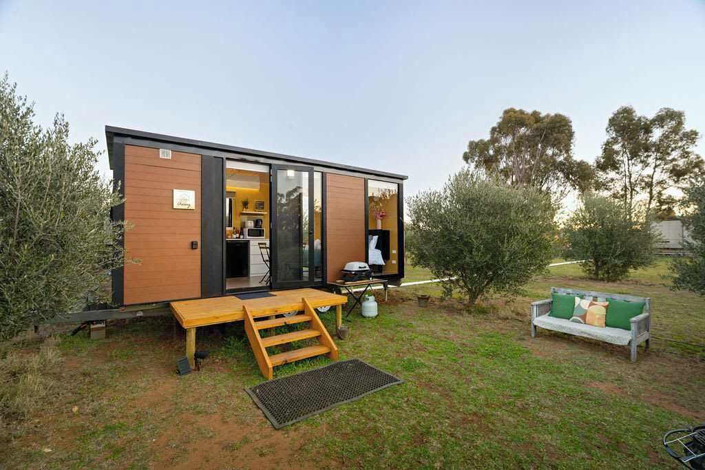 Eine moderne, eingeschossige Hütte mit Küche, Essbereich und Sitzgelegenheit im Freien.