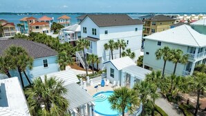 A resort with a swimming pool surrounded by palm trees, multiple buildings, and a view of the ocean. - Twente Toes (Navarre)