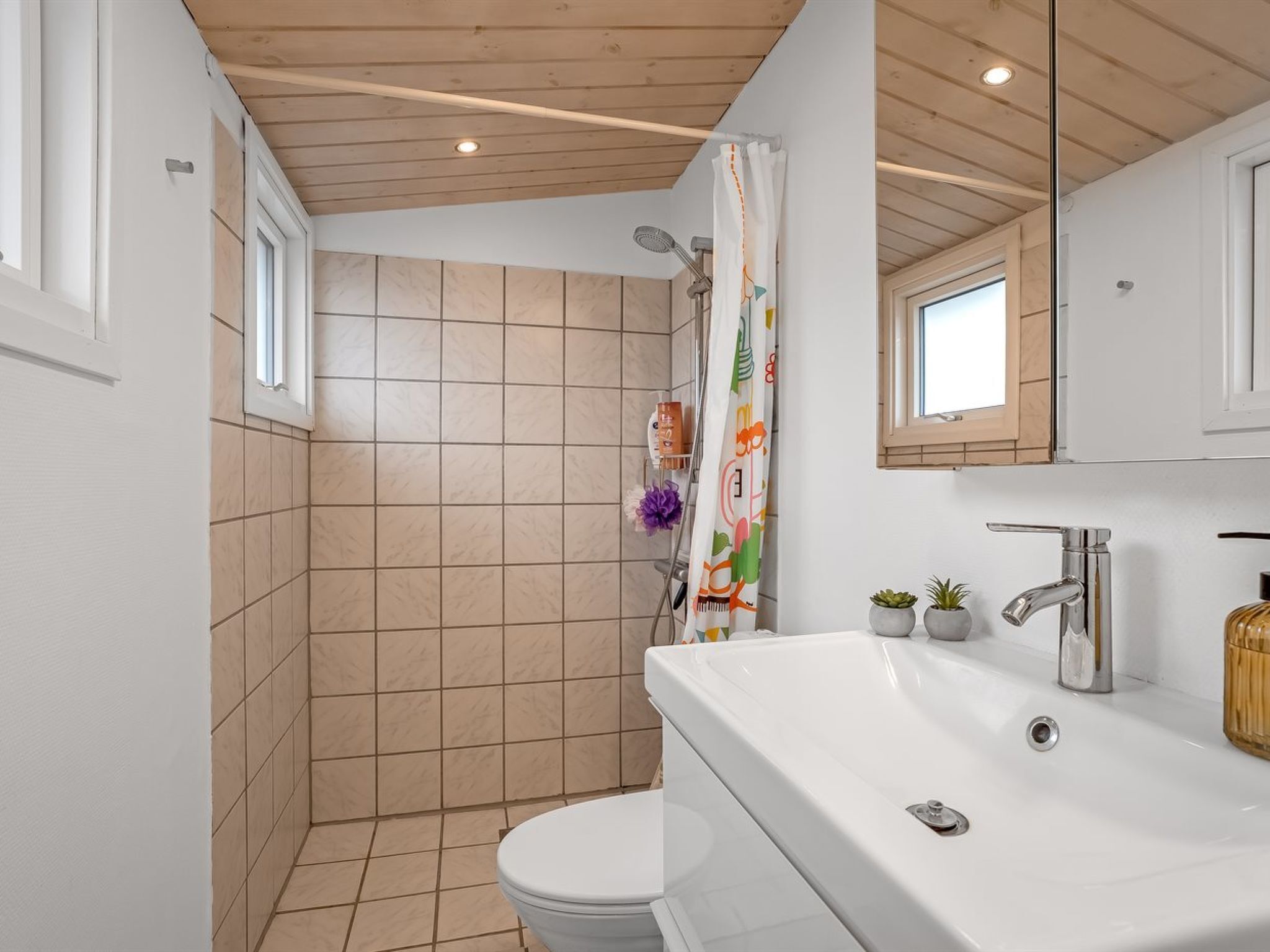 A bathroom with a bathtub, a toilet, and a shower area.