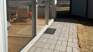 Een modern gebouw met grote schuifdeuren die uitkomen op een terras.