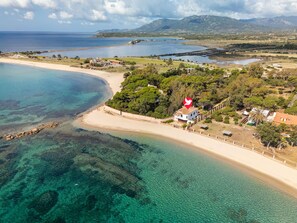 An aerial view of a coastal area with a beach, clear waters, and a house with a red heart-shaped sign. - Villa Grete by Interhome (Pula)