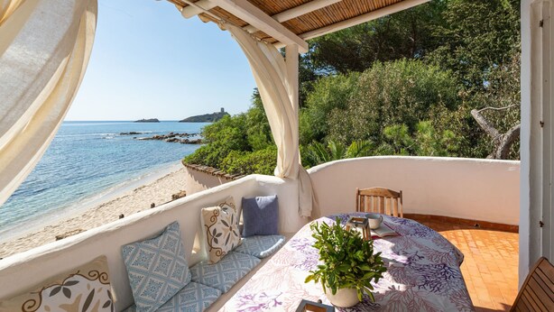 A balcony with a view of the sea, a table with a plant, and a chair. - Villa Grete by Interhome (Pula)