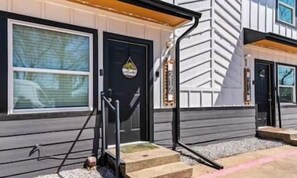 A house with a black front door, a small porch, and a window. - Modern Designer Oasis 208 (Irving)