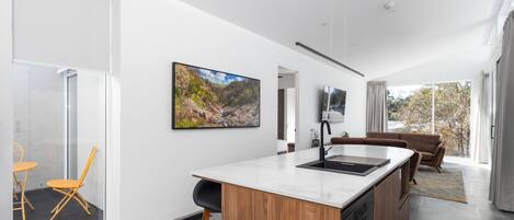 Una cocina moderna con una isla grande, armarios de madera y lavavajillas integrado.