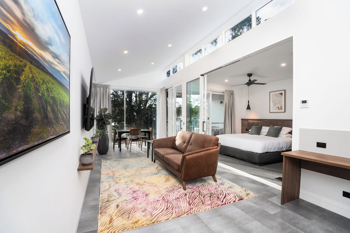 Ein modernes Wohnzimmer mit Sofa, Bett und Essbereich.