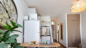 A compact kitchen with a refrigerator, microwave, and a clock on the wall. - Apartment Jac by Interhome (Tossa de Mar)