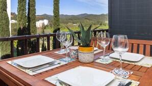 A wooden table set for dining with a view of the countryside. - Apartment Jac by Interhome (Tossa de Mar)