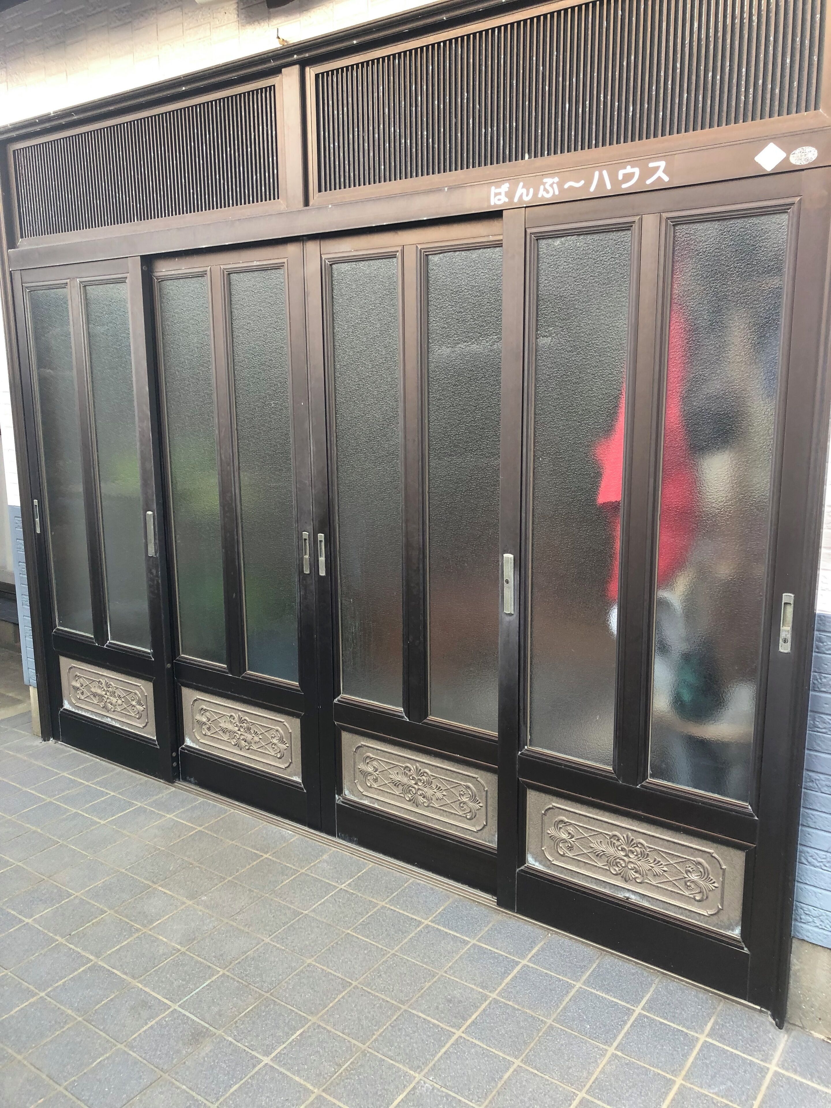A row of black metal lockers with reflective glass doors and a ventilation system above.