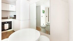 Een moderne badkamer met een grote spiegel, witte sanitair en een zichtbaar toilet.