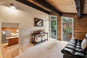 A modern interior with a kitchen, a dining area, and a living room with a leather couch.
