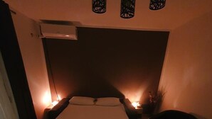 Un dormitorio con una cama, lámparas de noche, un calentador y una alfombra estampada.