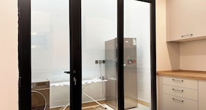 A modern kitchen with a refrigerator, a microwave, and a wooden countertop.