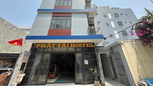 Un edificio de hostal con un letrero que dice "PHÁT TAI HOSTEL".