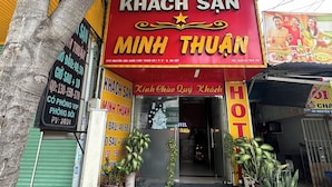 A building with a prominent red sign for 'KHÁCH SAN MINH THUẬN' and a smaller sign for 'HOTEL THUẬN'.