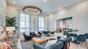 Eine moderne Hotelhalle mit Sitzgelegenheiten, einem Couchtisch und einem Essbereich.
