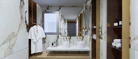 Un baño moderno con paredes de mármol, dos lavamanos, un perchero para albornoces y un espejo.