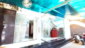 A building entrance with a glass door, a staircase leading inside, and a parked motorcycle outside. - Do Gia Hotel (Ho Chi Minh City)