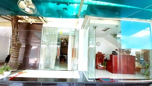 A hotel entrance with a glass door, a staircase leading up, and a clock on the wall. - Do Gia Hotel (Ho Chi Minh City)