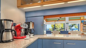 Une cuisine moderne avec des meubles bleus, une machine à café et une bouilloire.