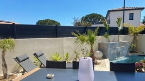 A patio with a table, chairs, and a small pool. - Maison / Piscine, Proche Plages (Vic-la-Gardiole)