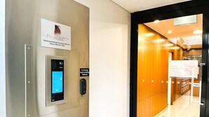 Un ascenseur doté d’un écran numérique et d’un panneau indiquant qu’il est interdit de fumer.