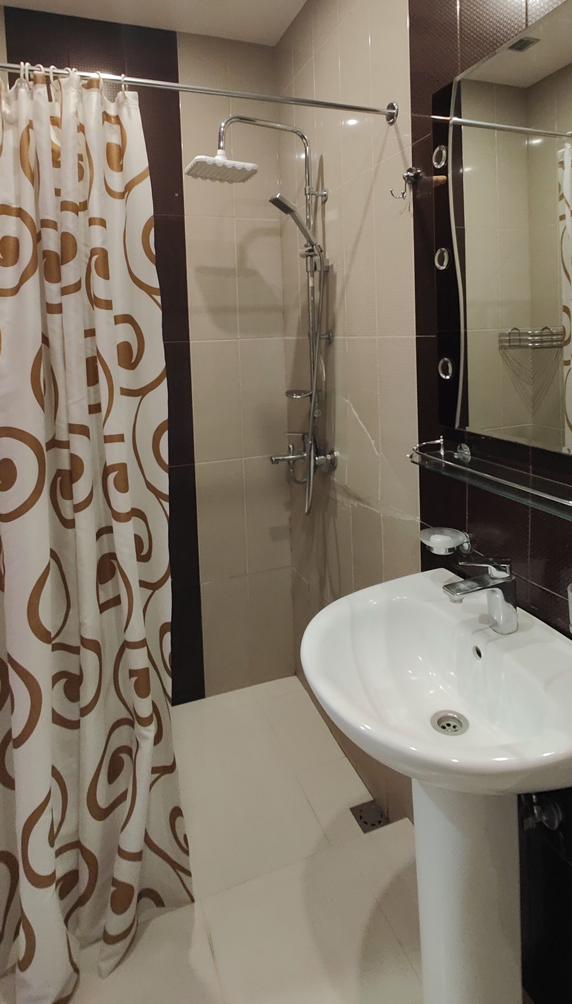 A bathroom with a shower, a sink, and a mirror.