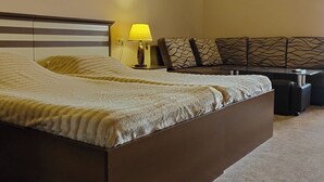 Ein modernes Schlafzimmer mit gewölbter Decke, einem großen Bett, Nachttischlampen und einer dekorativen Wandverkleidung.